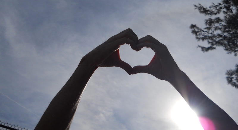 photo of hands in the sky making a heart shape