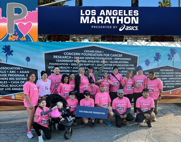 group of participants wearing pink shirts and running shoes, kneeling below a banner with text in the shape of the Dodger's marquee
